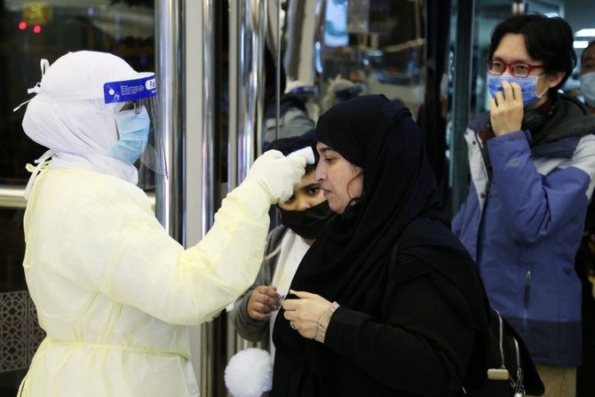 Passengers have their temperature checked by Saudi Health Ministry employees upon their arrival at King Khalid International Airport, in Riyadh, Saudi Arabia. (File/Reuters)