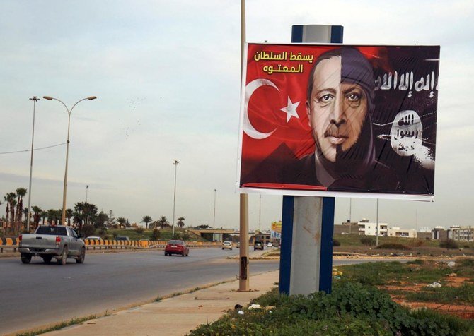 This file photo taken on February 13, 2020, shows a billboard depicting the Turkish President Recep Tayyip Erdogan as a member of the Daesh group the in the eastern Libyan port city of Benghazi, with a caption in Arabic reading “down with the idiot Sultan.” (File/AFP)