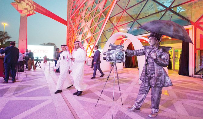 A handout picture provided by the Saudi Royal Palace on April 18, 2018, shows a mime actor standing behind a model vintage cinema camera at the entrance of the AMC cinema in the capital Riyadh ahead of the first test film screening in over three decades. (AFP)