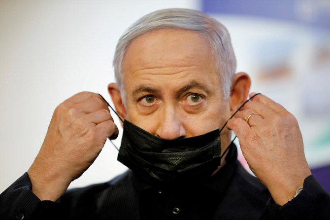 Israeli Prime Minister Benjamin Netanyahu adjusts his protective face mask after receiving a coronavirus disease (COVID-19) vaccine at Sheba Medical Center in Ramat Gan, Israel December 19, 2020. (Reuters)