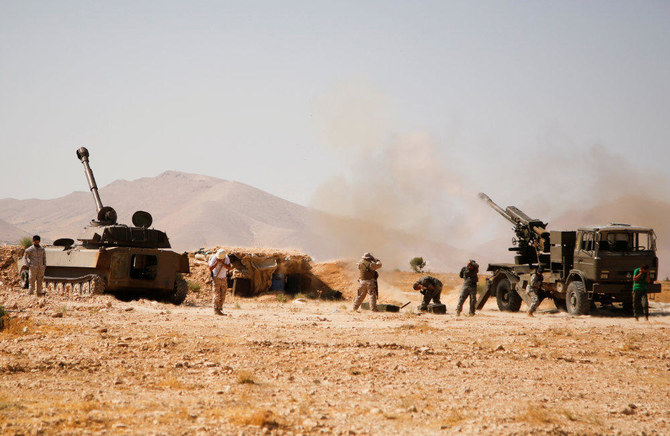 In this August 23, 2017 photo, Hezbollah fighters stand near military tanks in Western Qalamoun, Syria. Hezbollah's chief on Sunday said the Iran-backed militia has the capability of striking back at Israel. (REUTERS/Omar Sanadiki/File Photo)