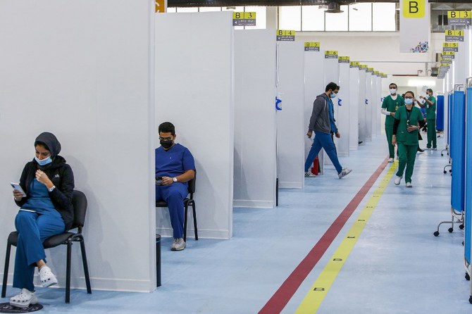 People wait for their turn to be vaccinated for COVID-19 coronavirus at the make-shift vaccination centre erected at the Kuwait International Fairground in the Mishref suburb south of Kuwait City on Dec. 29, 2020. (File/AFP)