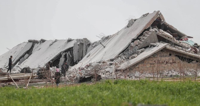 Displaced Syrian men check the destruction at a poultry farm in Idlib. (AFP/File)
