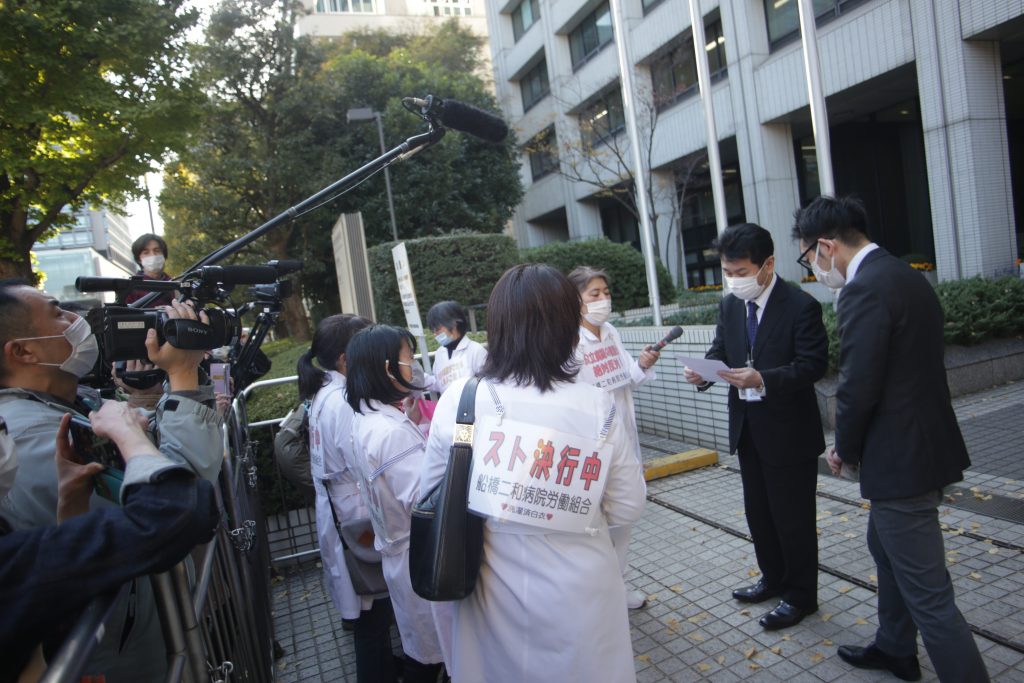 Nurse hold a banner, on strike written on it , at Funabashi city. (ANJ Photo)