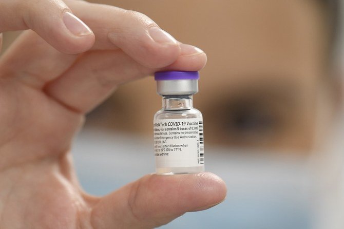 In this file photo taken on December 08, 2020 a member of staff poses with a phial of Pfizer-BioNTech Covid-19 vaccine at a vaccination health centre in Cardiff, South Wales'. (AFP)