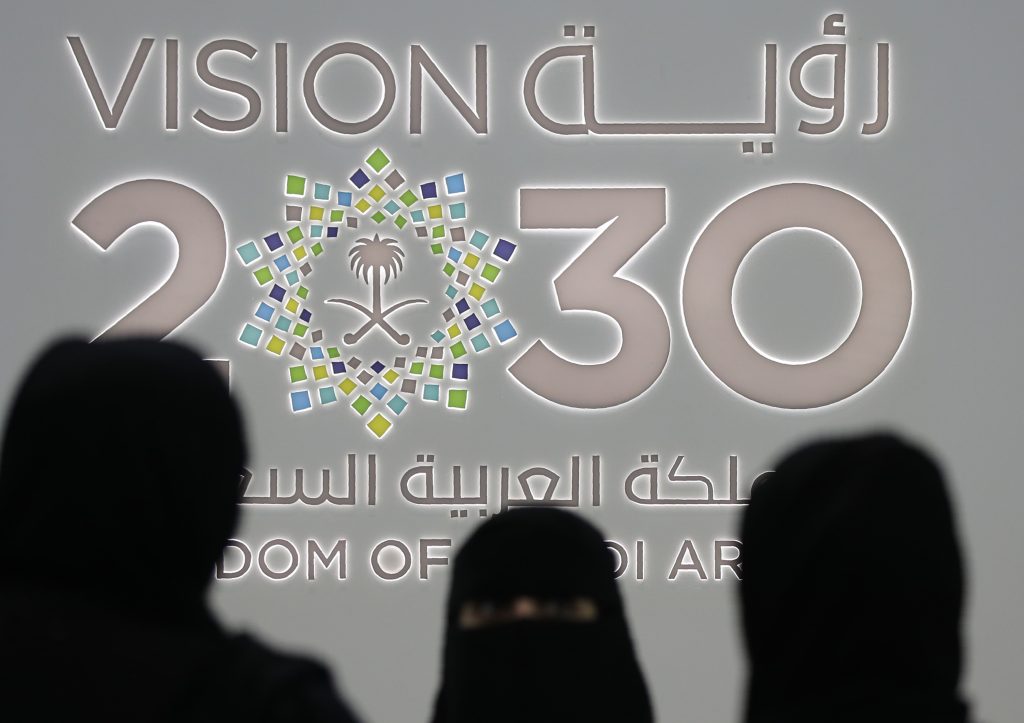 Saudi women stand next to the Saudi pavilion (vision 2030) at the Gitex 2018 exhibition at the Dubai World Trade Center in Dubai on October 16, 2018. Gitex (