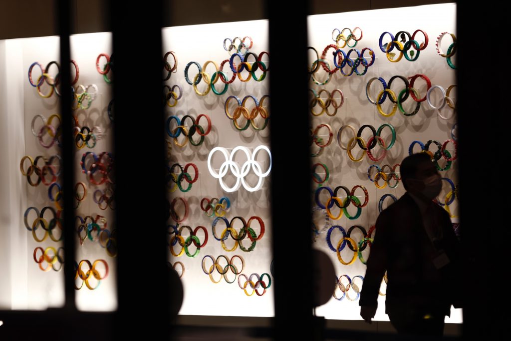 A man wearing a face mask walks past Olympic Rings at the Japan Olympic Museum in Tokyo on January 8, 2021, as Tokyo Olympics organisers insisted that the coronavirus-postponed Games will still go ahead despite Japan declaring a state of emergency less than 200 days before the opening ceremony. (AFP)