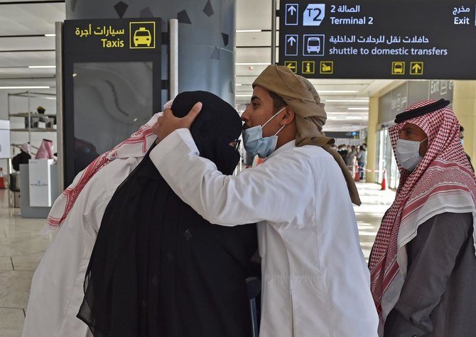 A man hugs his sister who arrived at King Khalid International Airport in the Saudi capital Riyadh on the first commercial flight from Qatar, on January 11, 2021. (AFP)
