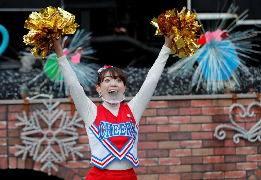 Head cheerleader Kumi Asazuma wearing a protective face shield, amid the coronavirus disease (COVID-19) outbreak, dances to cheer people up in front of Shimbashi Station during the commuting hour in Tokyo, Japan, January 7, 2021. (Reuters)