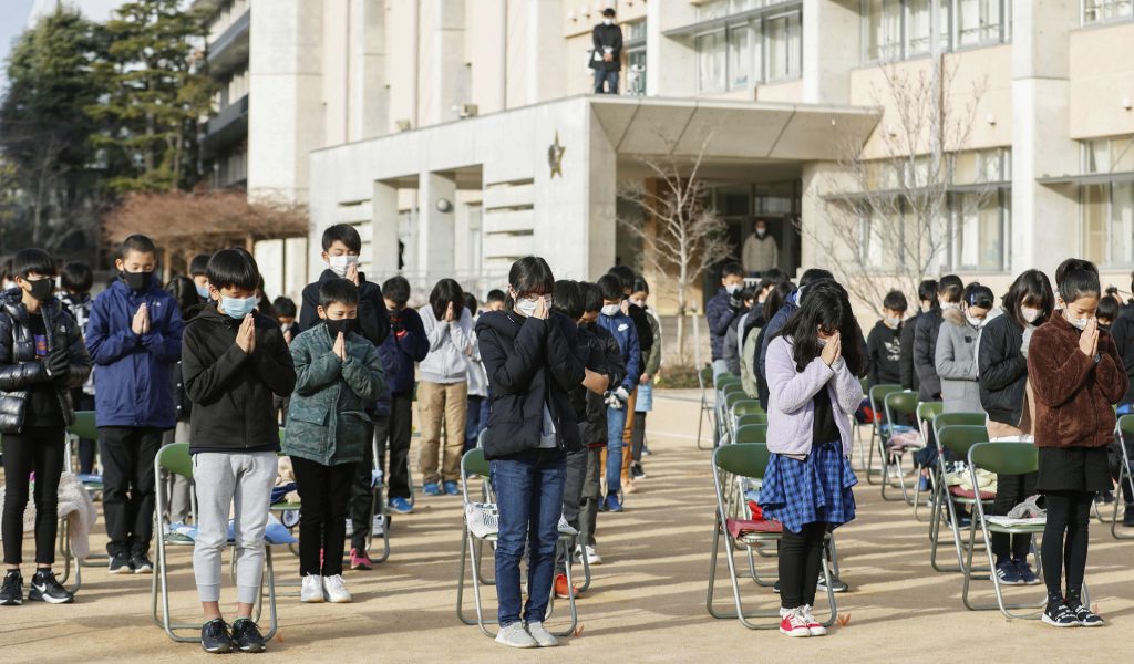 Students observer a moment of silence for the 26th anniversary of an earthquake, at an elementary school in Ashiya, western Japan, Sunday, Jan. 17, 2021. Ashiya was one of the cities affected by the quake that killed over 6,000 people on Jan. 17, 1995. (Miki Matsuzaki/Kyodo News via AP)