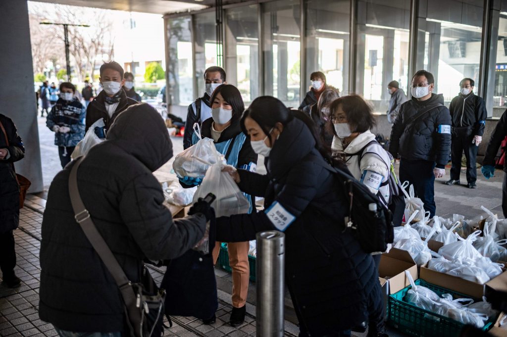 Volunteers from non-profit organization Moyai Support Centre for Independent Living giving out food handouts to people in need in the Shinjuku district of Tokyo, Jan. 9, 2021. (File Photo/AFP)