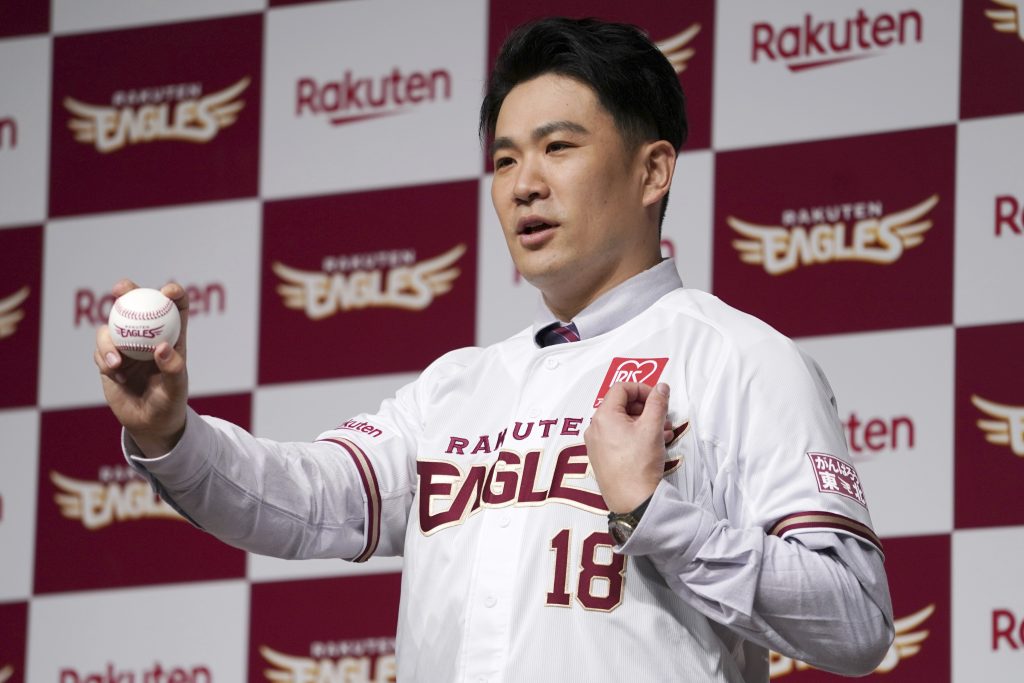 Former New York Yankees pitcher Masahiro Tanaka on his new uniform poses for a photo session during a news conference Saturday, Jan. 30, 2021 in Tokyo. Tanaka returned to Japan to rejoin the Rakuten Golden Eagles in the Nippon Professional Baseball League. (AP Photo/Eugene Hoshiko)