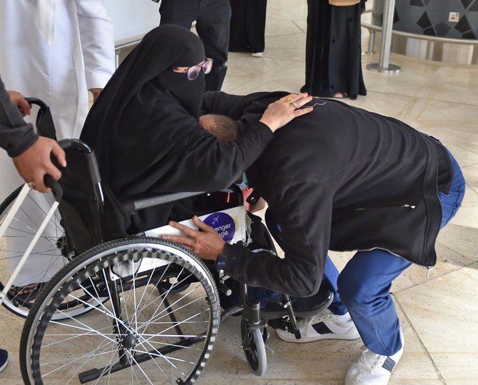 A man embraces his sister who just arrived to the King Khalid International Airport in the Saudi capital Riyadh on the first commercial flight from Qatar, on January 11, 2021. (AFP)