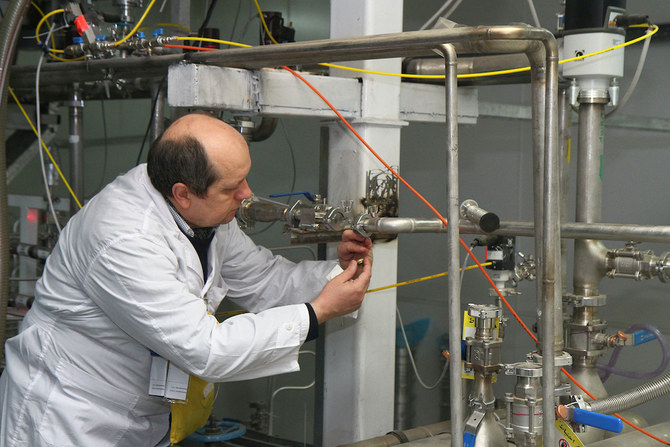 An unidentified International Atomic Energy Agency (IAEA) inspector disconnects the connections between the twin cascades for 20 percent uranium production at nuclear research center of Natanz, some 300 kilometers south of Tehran. (File/AFP)
