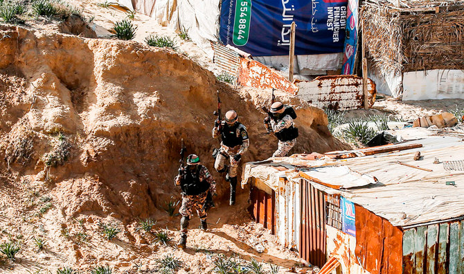 Armed fighters take part in a military drill by Hamas and other Palestinian armed factions on a beach in Gaza City. (AFP)