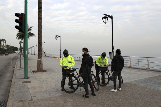 Police issue fines to civilians violating health safety measures on the waterfront promenade in Beirut, Lebanon, Thursday, Jan. 7, 2021. (AP)