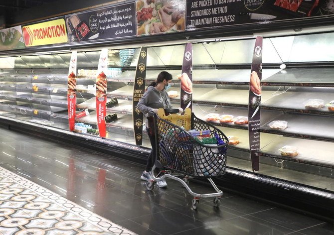 A customer pushes her trolley next to near empty shelves after people hoarded food as authorities are discussing the latest measures to implement to curb the spread of the coronavirus disease (COVID-19), in Beirut, Lebanon, January 11, 2021. (Reuters)