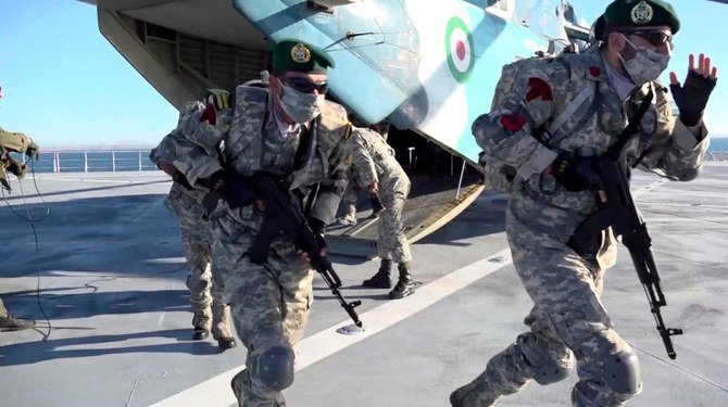 Troops alight from a helicopter on the Makran logistics vessel during a short-range missile drill drill by the Iranian Navy in the Gulf of Oman on Jan. 13, 2021. (Iranian Army via AP)