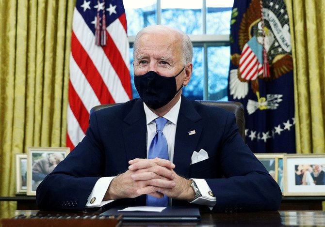 US President Joe Biden signs executive orders in the Oval Office of the White House in Washington, after his inauguration as the 46th President of the United States, January 20, 2021. (Reuters)