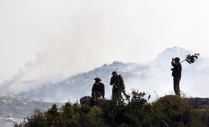 Syrian soldiers take a break as they battle a forest fire in the Ain Shams area, in the west of Hama province, on Sept. 10, 2020. (File/AFP)