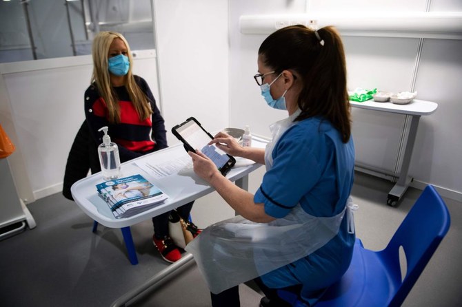 An immunisation nurse fills in forms prior to administering a COVID-19 vaccine to a staff nurse at a temporary hospital in Glasgow, Scotland on January 23, 2021. (AFP)