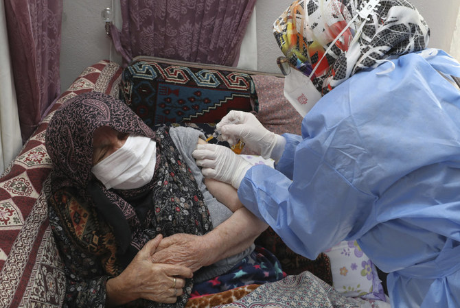 A Turkish Health Ministry health worker administers a dose of anti-COVID-19 vaccine on an 89-year-old woman in Ayas, in Ankara province, Turkey, on Jan. 21, 2021. (Turkish Health Ministry via AP)