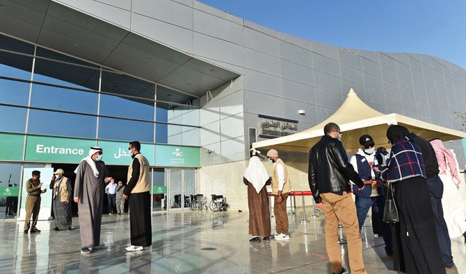 People gather outside the Riyadh International Convention and Exhibition Center, before receiving a dose of vaccine against the covid-19 disease, in the Saudi capital Riyadh, on January 21, 2021. (AFP)