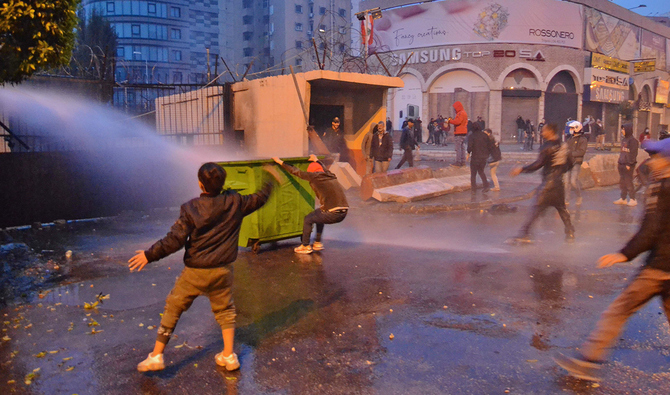 Lebanese security forces use water cannon to disperse protesters outside the Serail, headquarters of the Governorate of North Lebanon, during ongoing demonstrations in Lebanon's northern port city of Tripoli on January 27, 2021. (AFP)