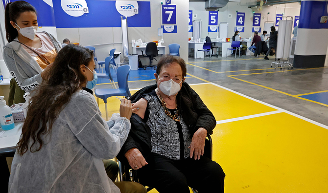 A health worker of the Maccabi Health vaccination centre administers a dose of the Pfizer-BioNtech COVID-19 coronavirus vaccine, inside the parking lot of the Givatayim mall in Israel's Mediterranean coastal city of Tel Aviv on January 26, 2021. (AFP)