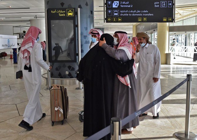 A man hugs his sister who arrived at King Khalid International Airport in the Saudi capital Riyadh on the first commercial flight from Qatar, on January 11, 2021. (AFP)