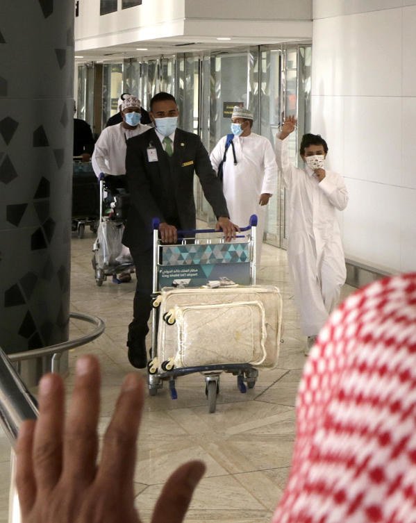 Qatari national, Khaled, 12, is greeted by his Saudi uncle as he arrives on the first Qatar Airways plane in three years to land at King Khalid Airport in Riyadh, Saudi Arabia, Monday, Jan. 11, 2021. (AP)