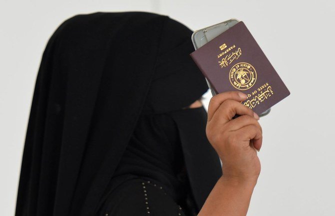 A woman flashes her Qatari passport upon arrival at King Khalid International Airport in the Saudi capital Riyadh on the first commercial flight from Qatar, on January 11, 2021. (AFP)