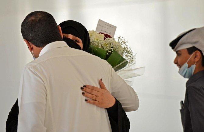 A man hugs his sister who arrived at King Khalid International Airport in the Saudi capital Riyadh on the first commercial flight from Qatar, on January 11, 2021. (AFP)