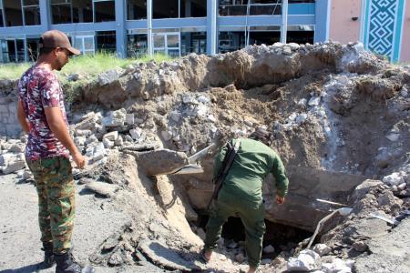 Fighters with the Saudi-backed coalition assess the damage outside the airport of Yemen's southern city of Aden on December 31, 2020, a day after explosions rocked the building, killing or injuring dozens of people. (AFP)