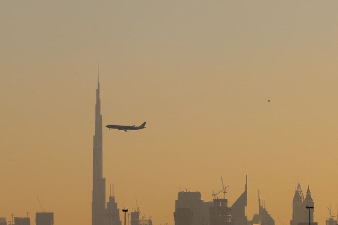 A commercial airplane flies past Burj Khalifa as it starts landing at Dubai international airport in the United Arab Emirates, on January 9, 2021. (AFP)