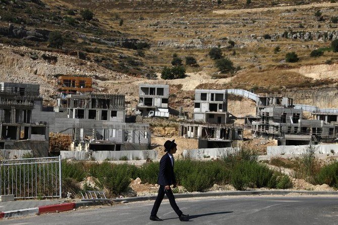 A Jewish settler walks past Israeli settlement construction sites around Givat Zeev and Ramat Givat Zeev in the Israeli-occupied West Bank, near Jerusalem, June 30, 2020. (Reuters)