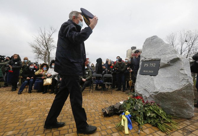A pilot lays flowers at a memorial in Kyiv, Ukraine, Friday, Jan. 8, 2021, for the victims of a Ukrainian 737-800 plane crash on the outskirts of Tehran. (AP)
