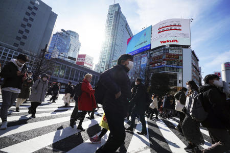 People wearing protective masks to help curb the spread of the coronavirus walk along pedestrian crossings Monday, Jan. 25, 2021 in Tokyo. (AP)