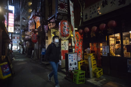 A man walks through an alley filled with restaurants and bars after 8 pm on the first day of a coronavirus state of emergency in Tokyo on Friday, Jan. 8, 2021. (AP)