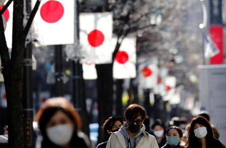 Pedestrians wearing protective masks, amid the coronavirus disease (COVID-19) outbreak, make their way at Ginza shopping district which closed to cars on Sunday in Tokyo, Japan, January 10. (Reuters)