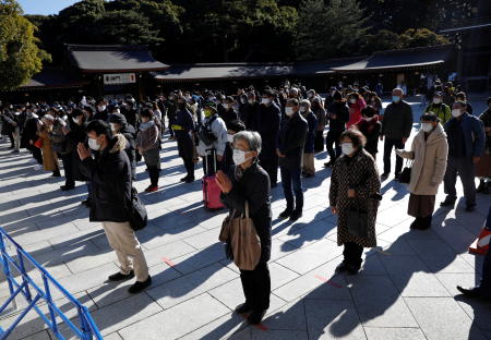 People wearing protective masks, amid the coronavirus disease (COVID-19) outbreak, pray on the first day of the New Year at the Meiji Shrine in Tokyo. (Reuters)
