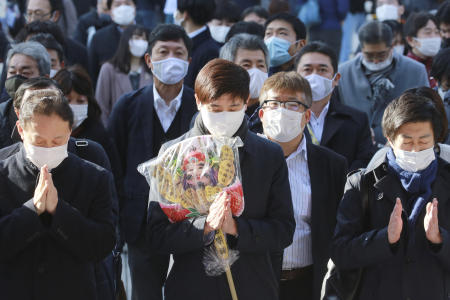 People wearing face masks to protect against the spread of the coronavirus offer prayers for New Year at the Kanda Myojin Shrine on the first business day of the year, in Tokyo, Monday, Jan. 4, 2021. (AP)