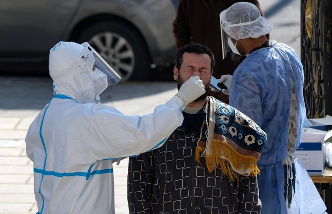 A member of the Jordanian health ministry's epidemiological investigation team, takes a random nasal swab to test for COVID-19 in Amman. (AFP/File)
