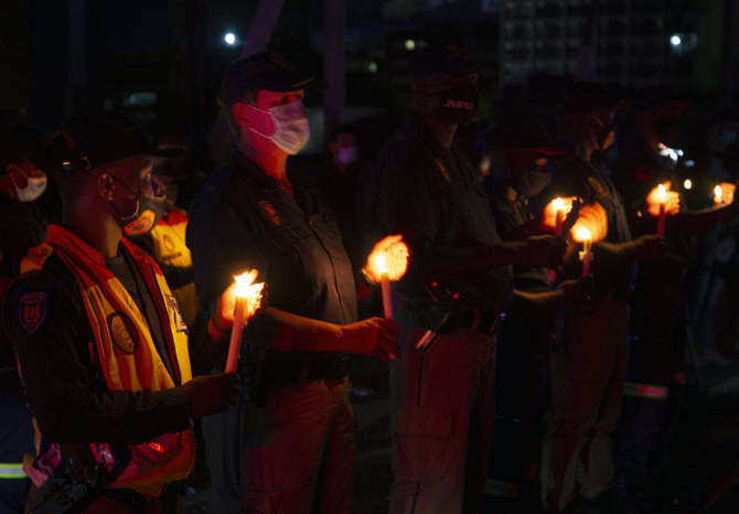 Frontline workers attend a candlelight ceremony on New Year's Eve on the famed Nelson Mandela Bridge in downtown Johannesburg on Dec. 31, 2020. (AP)