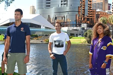 Spanish tennis player Rafael Nadal (center) smiles as he joins women's world number three Naomi Osaka (right) of Japan and men's world number one Novak Djokovic of Serbia at an event 