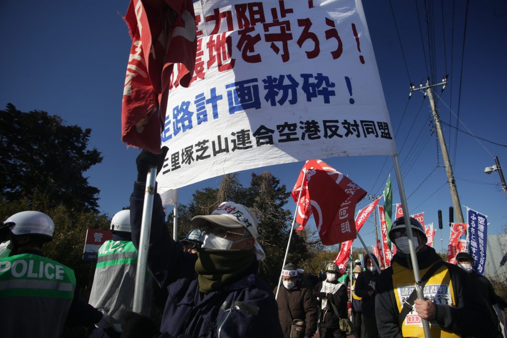 Police keep an eye on the protesters as they demonstrate in support of Takao Shito, who is facing eviction from his land next to Narita Airport. (ANJ photo)