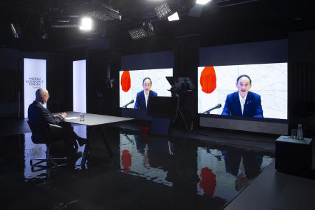 German Klaus Schwab (left), Founder and Executive Chairman of the World Economic Forum (WEF), listens to Japanese Prime Minister Suga Yoshihide displayed in screens during a video conference at the Davos Agenda, in Cologny near Geneva, Switzerland, Friday, January 29, 2021. (AP)