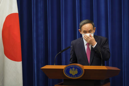 In this Dec. 25, 2020, file photo, Japan's Prime Minister Yoshihide Suga adjusts a face mask after a press conference on the COVID-19 situation in Japan at the prime minister's office in Tokyo. (AP)