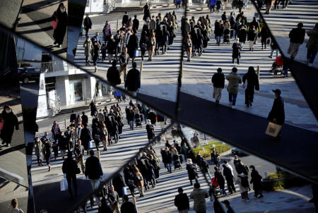Year-end shoppers wearing protective face masks are reflected on mirrors at a shopping and amusement district, amid the coronavirus disease (COVID-19) outbreak, in Tokyo, December 31, 2020. (Reuters)
