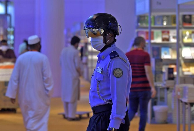 An Emirati policeman uses a smart helmet to detect people’s temperature as a tool to fight the spread of the COVID-19 in Sharjah, northeast of Dubai. (File/AFP)